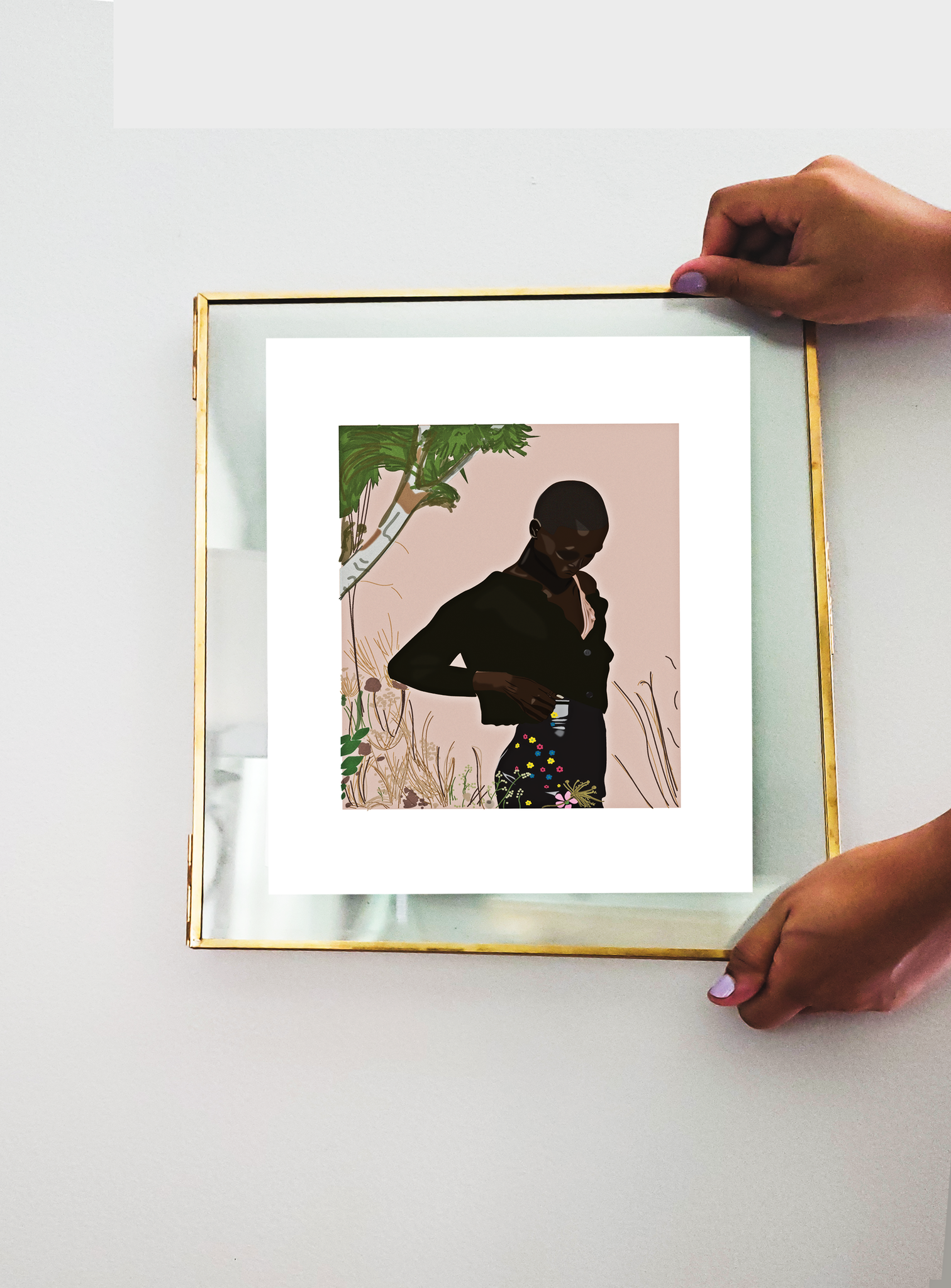 Two hands holding up a transparent frame with an illustration print inside of model Amar Akway posing in a garden wearing a Miu Miu cropped sweater and mini skirt