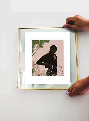 Two hands holding up a transparent frame with an illustration print inside of model Amar Akway posing in a garden wearing a Miu Miu cropped sweater and mini skirt