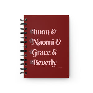 A red notebook with light pink text that reads "Iman & Naomi & Grace & Beverly" in reference to the Black models Iman Abdulmajid, Naomi Campbell, Grace Jones, and Beverly Johnson