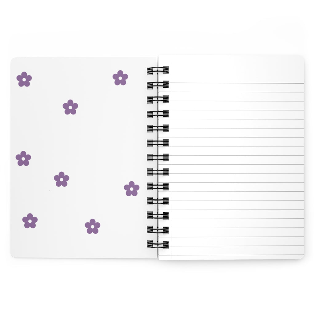 The white inside cover of a spiral journal with small light purple flowers printed on it