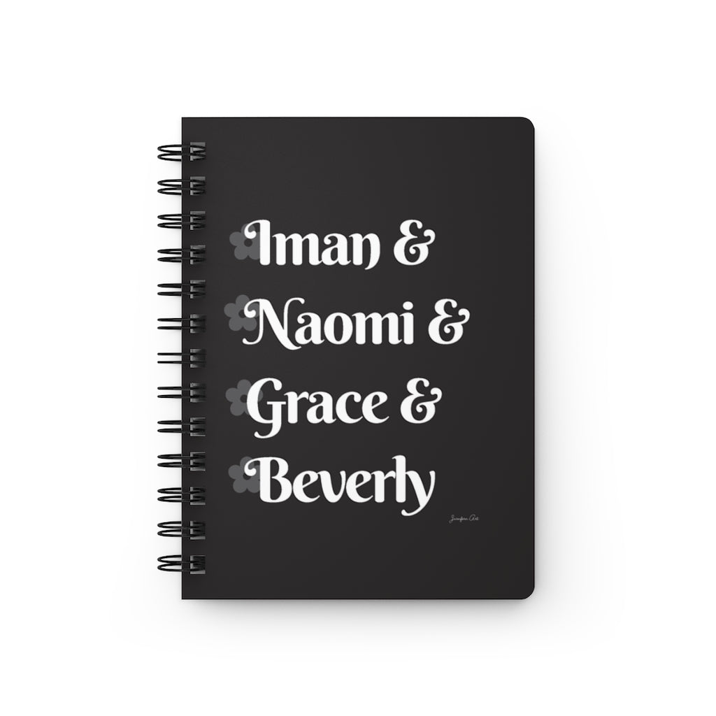 A black notebook with white text that reads "Iman & Naomi & Grace & Beverly" in reference to the Black models Iman Abdulmajid, Naomi Campbell, Grace Jones, and Beverly Johnson