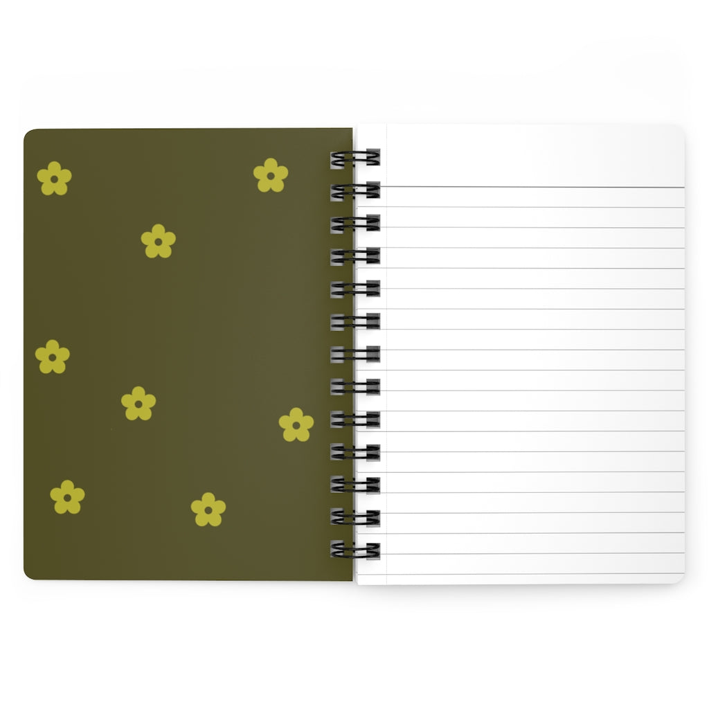 The dark yellow inside cover of a spiral journal with small light yellow flowers printed on it