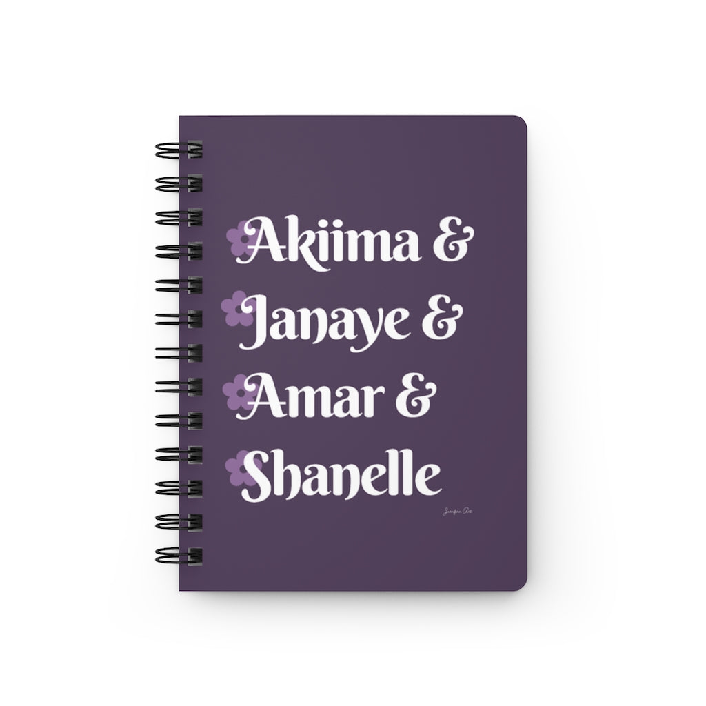 A light purple notebook with white text that reads "Akiima & Janaye & Amar & Shanelle" in reference to the Black models Akiima Ajak, Janaye Furman, Amar Akway, and Shanelle Nyasiase