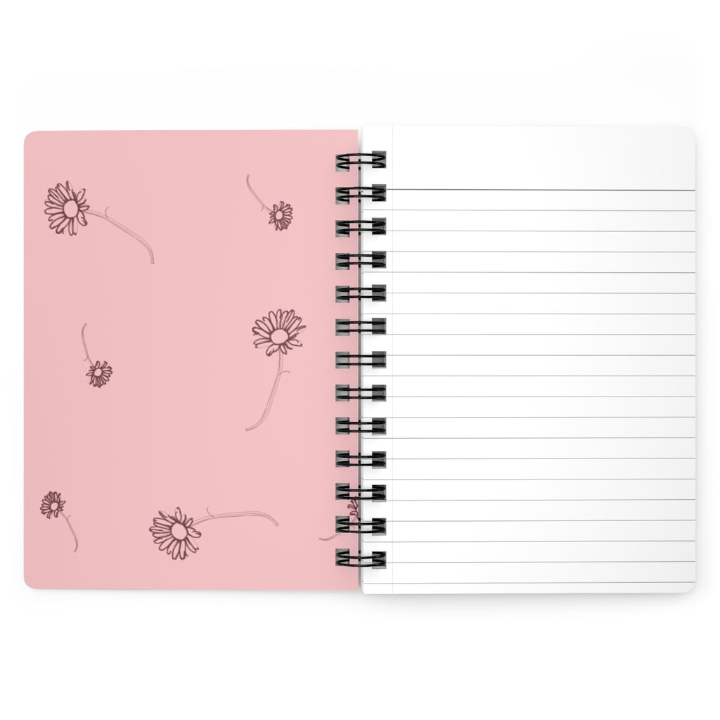 The inside cover of a lined journal that is light pink with simple dark red flowers