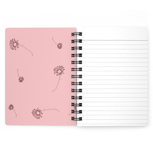 The inside cover of a lined journal that is light pink with simple dark red flowers