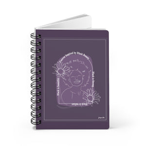 A monochrome purple spiral journal with a line drawing on the cover of a Black woman with an afro surrounded by flowers and text that reads "Forever Inspired by Black Beauty"