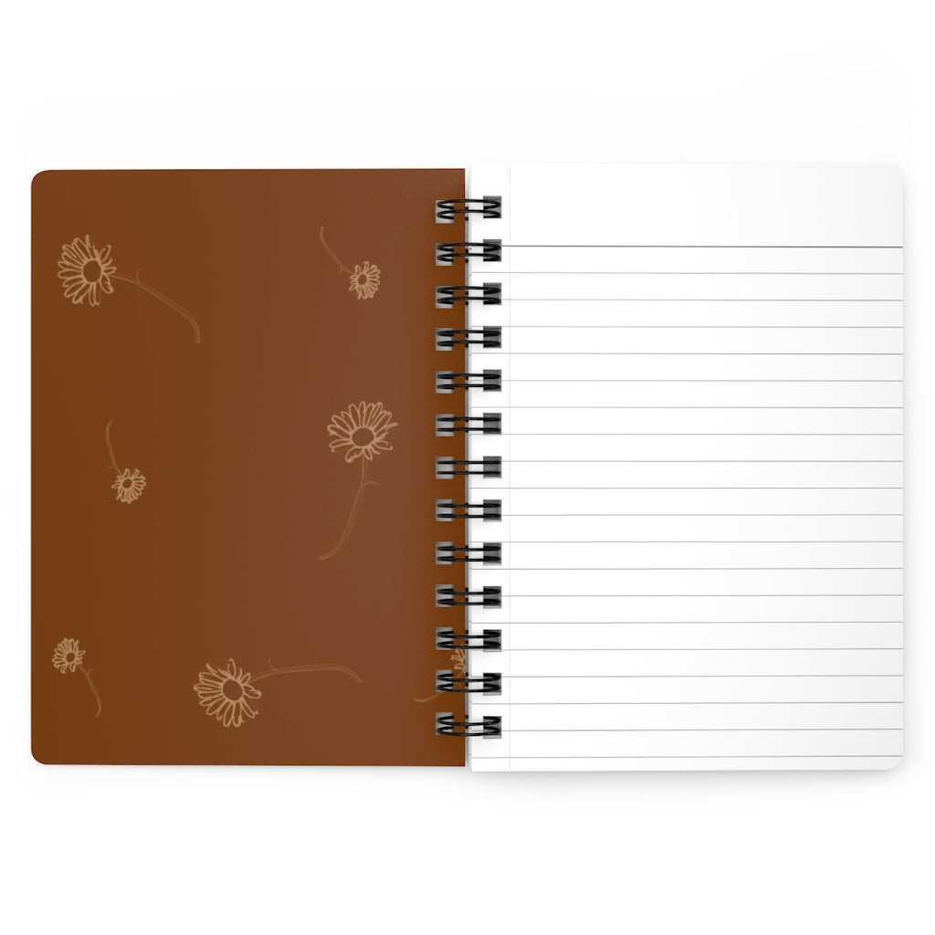 The inside cover of a lined journal that is dark orange with simple light orange flowers