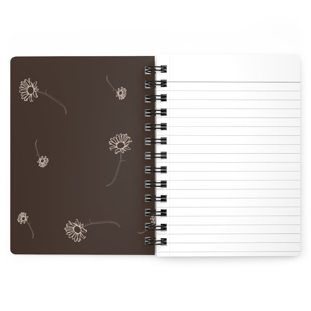 The inside cover of a lined journal that is brown with simple beige flowers