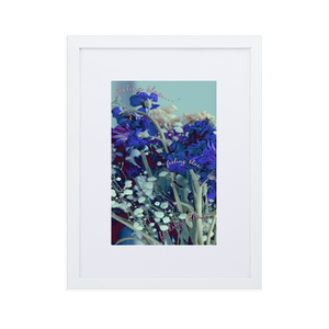 A close-up blue and purple flower photo inside of a white frame with a white mat boarder
