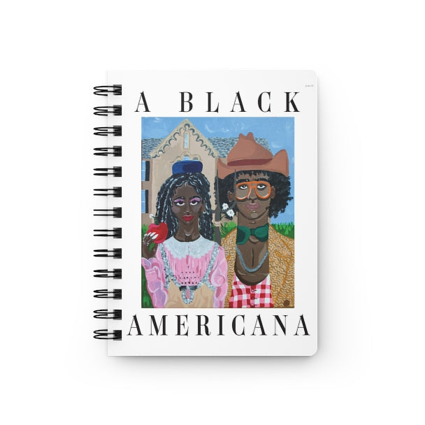 A spiral journal with a painting on the cover reminiscent of the classic American Gothic, but with a Black couple wearing 'rural' outfits by Gucci and black text that reads “A Black Americana.”