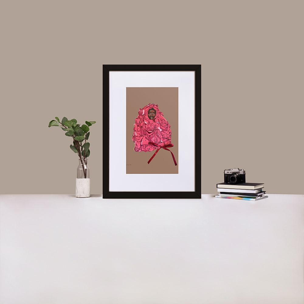 A black framed print with white board matting, with an illustration of Black supermodel Adut Akech wearing a pink Valentino gown with a bow on it, with a nude background color, standing up on a table next to a green plant and a stack of books