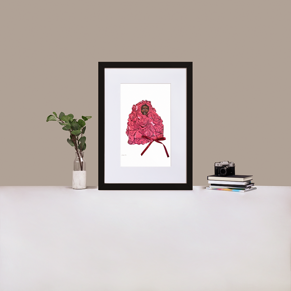 A black framed print with white board matting, with an illustration of Black supermodel Adut Akech wearing a pink Valentino gown with a bow on it, with a white background, standing up on a table next to a green plant and a stack of books