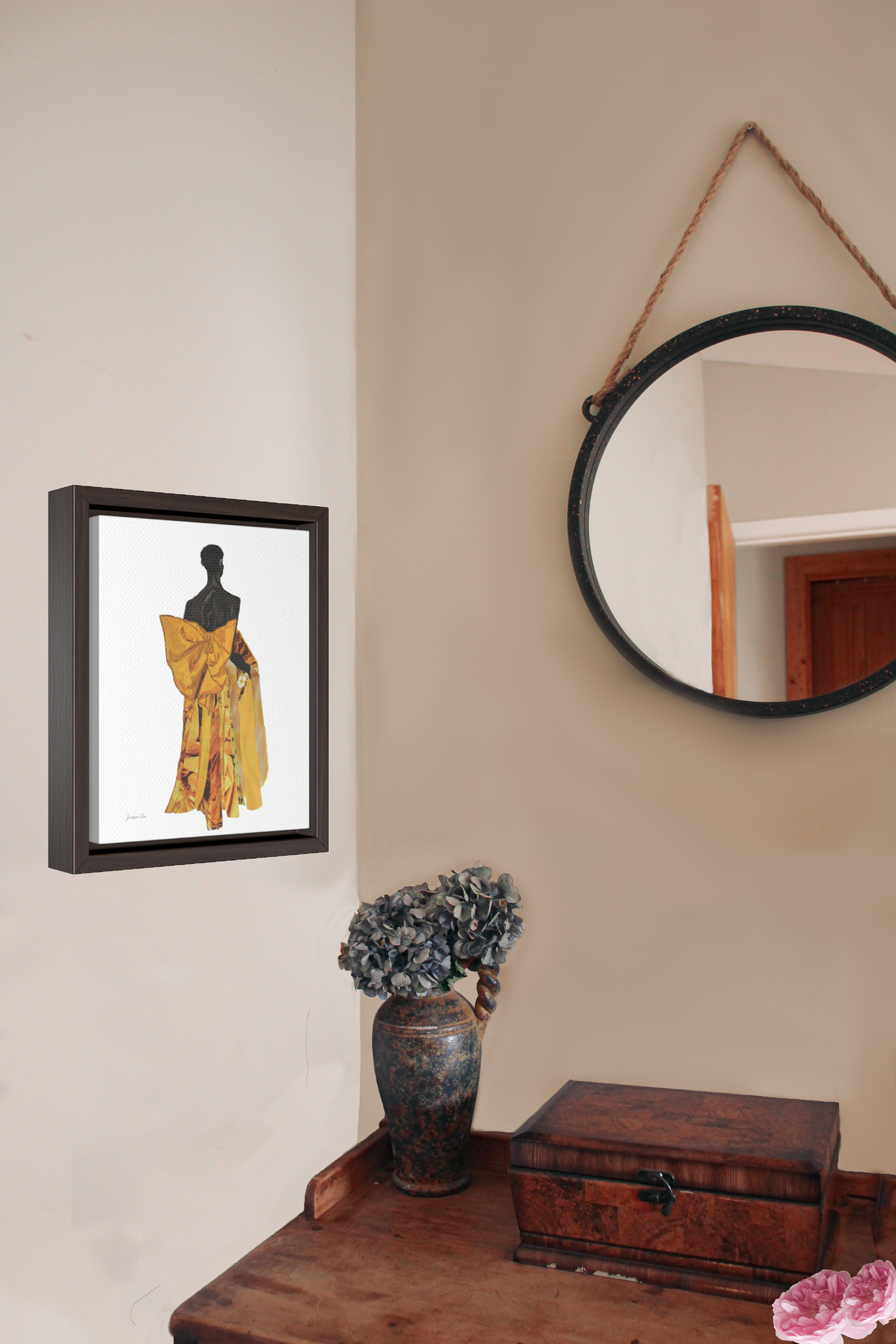 A framed canvas featuring a fashion illustration of Black model Akiima Ajak wearing a yellow Valentino gown with a large bow on the back, and a white background, hanging on a wall above a wood desk with a vase of flowers
