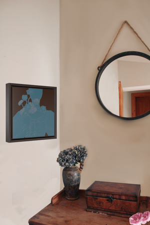 A framed canvas illustration of a monochrome blue portrait of a woman holding a vase of flowers, hanging on wall next to a hanging circle mirror and a dark wood desk