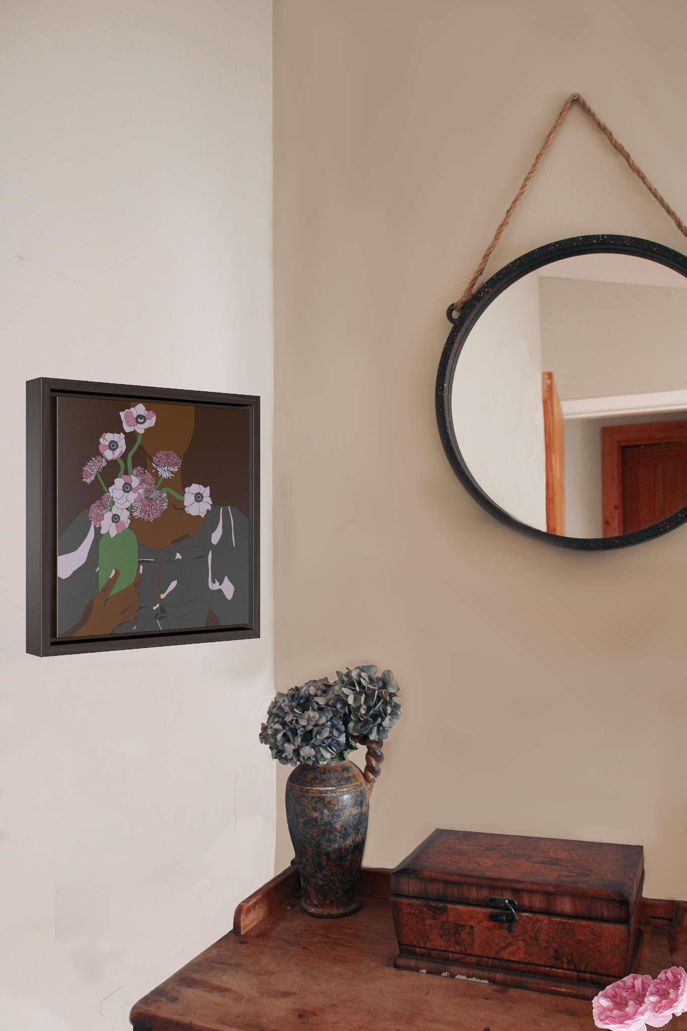 A framed canvas illustration of a portrait of a Black woman holding a vase of flowers, hanging on a wall next to a wood desk and a hanging circle mirror
