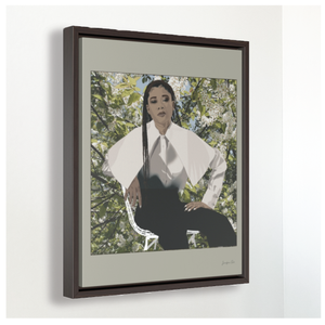 A large framed canvas illustration with a beige background and a digital illustration of actress Storm Reid posing in a chair and wearing a white blouse and black trousers, with a photo of flowers and leaves behind her