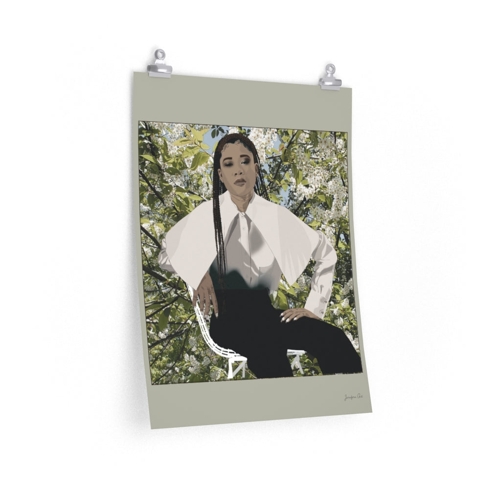 A 18 by 24 inch poster with a beige background and a digital illustration of Storm Reid posing in chair and wearing a white blouse with black trousers, with a photo of flowers and leaves behind her