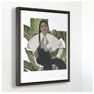 A large framed canvas illustration with a white background and a digital illustration of actress Storm Reid posing in a chair and wearing a white blouse and black trousers, with a cut-out photo of leaves behind her