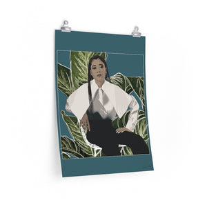 A 18 by 24 inch poster with a teal background and a digital illustration of Storm Reid posing in chair and wearing a white blouse with black trousers, with a cut-out photo of leaves behind her